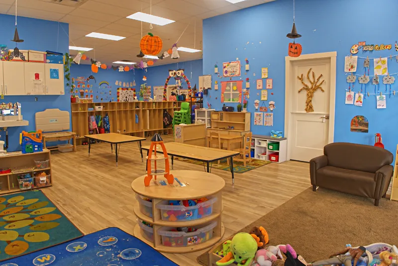 Blue room with a round toy station and soft seating