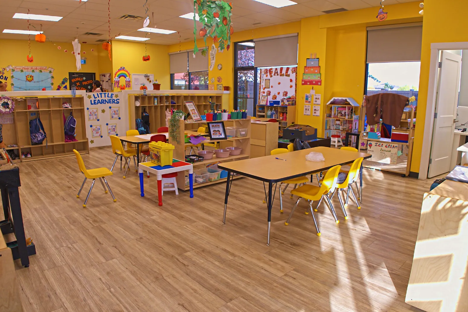 Bright classroom set up for the day with tables and cubbies